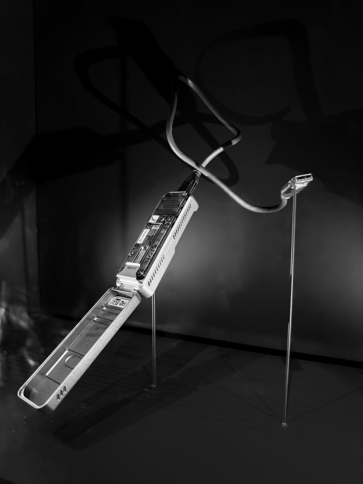 An Oxford Nanopore MinION sequencer mounted on stands with its flow-cell bay open and its USB cable arcing overhead